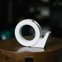 木製の台の上に置かれた白いテープカッターの写真