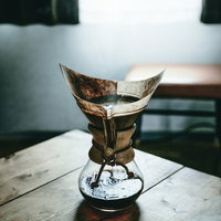 木製テーブル上でドリップ中の珈琲、カフェの時間の写真