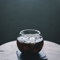 グラスに注がれたアイスコーヒーの表面に泡立つ泡の写真