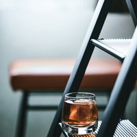 棚に置かれた大きな氷が浮かぶ麦茶のグラスの写真