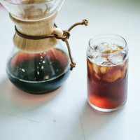 ガラス製コーヒーメーカーとドリップ仕立てのアイスコーヒーの写真