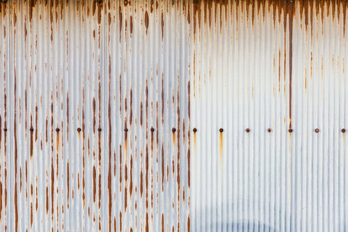 トタン板の錆び付いた波状の表面 - 風化した金属板のテクスチャー