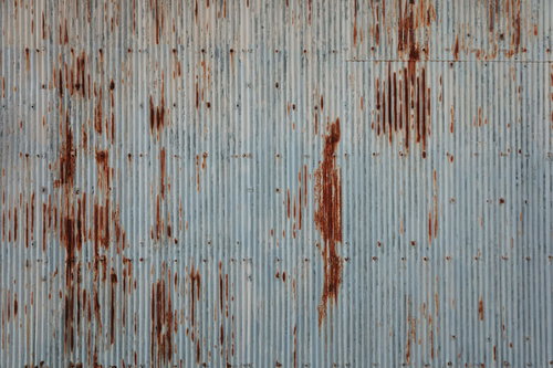 老朽化が進み錆び付いたトタン板の波状表面