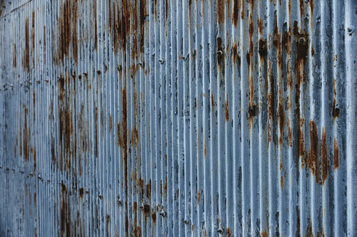 錆び付いた波板トタン外壁の老朽化テクスチャー