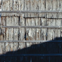 ボロボロに劣化した板を張り合わせた古い壁の写真