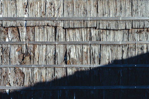 ボロボロに劣化した板を張り合わせた古い壁