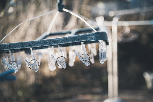 劣化したピンチハンガーに掛かった透明の洗濯バサミ