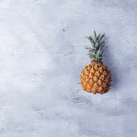 コンクリート背景に置かれたパイナップルの果物の写真