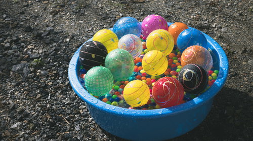 桶いっぱいに詰まったカラフルな水風船とヨーヨー