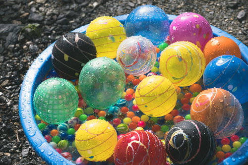水に濡れた色とりどりの水風船とスーパーボール