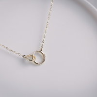 白い皿に置かれた贈り物のゴールドネックレスの写真