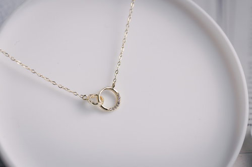 白い皿に置かれた贈り物のゴールドネックレス