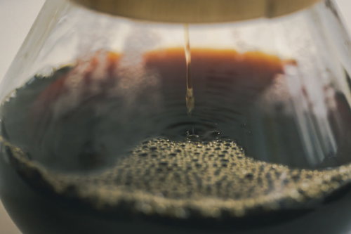 コーヒーの雫が落ちて波紋を作るドリップコーヒーの抽出シーン