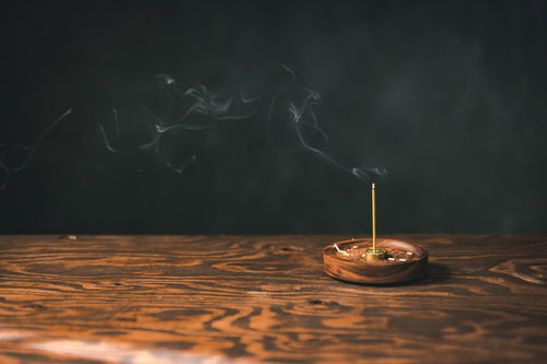 木製のお香立てから煙立つお香