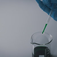 怪しい液体をスポイトでビーカーへ滴下する実験の写真