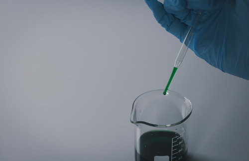 怪しい液体をスポイトでビーカーへ滴下する実験