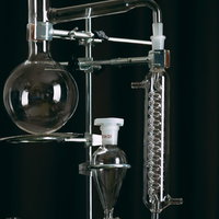 透明なガラス製の丸いフラスコと実験器具のの写真