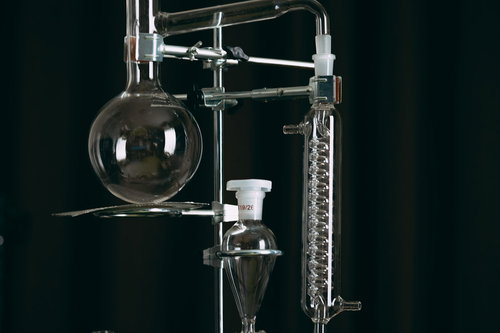 透明なガラス製の丸いフラスコと実験器具の