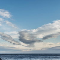 流れる雲と大海原の水平線 青い空の自然風景の写真