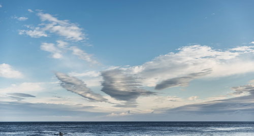 流れる雲と大海原の水平線 青い空の自然風景