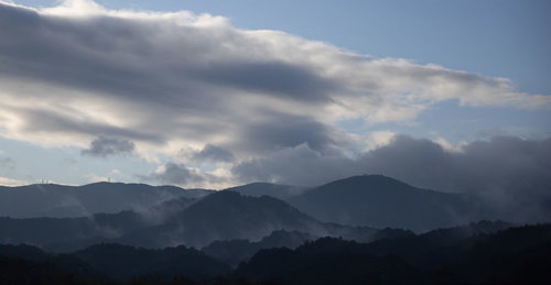 雨上がりにガスがかかる山々の夕暮れ時の山脈風景