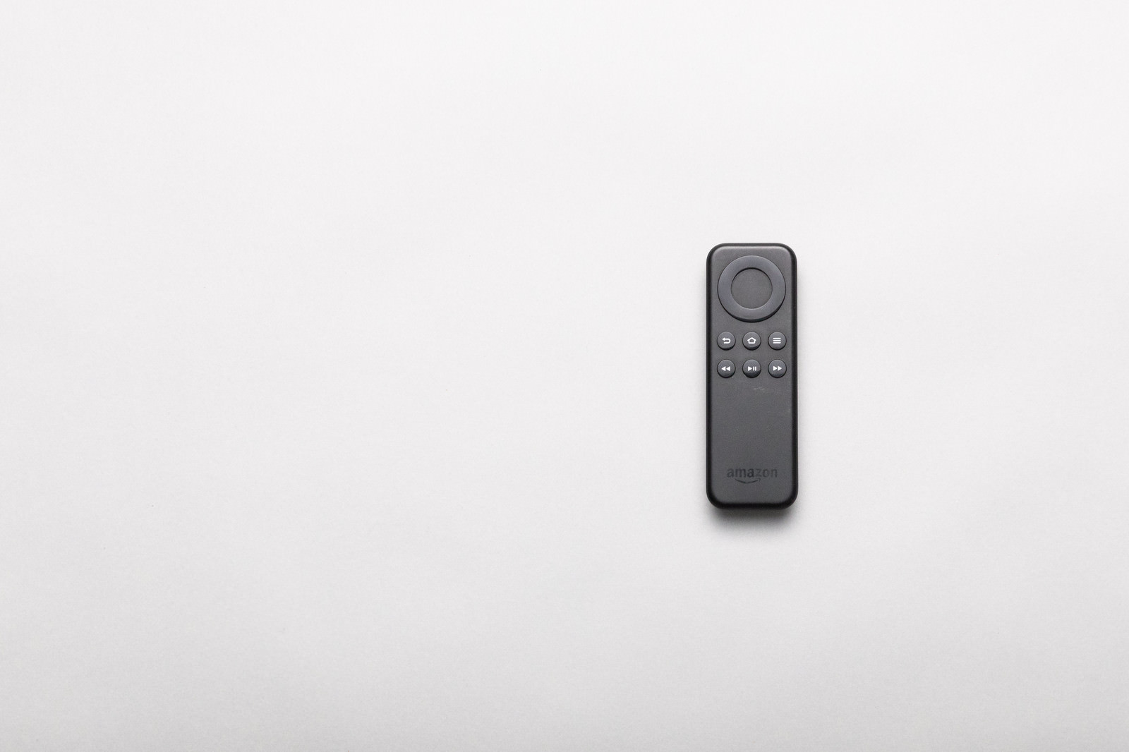Black Fire TV Stick remote control on a white background