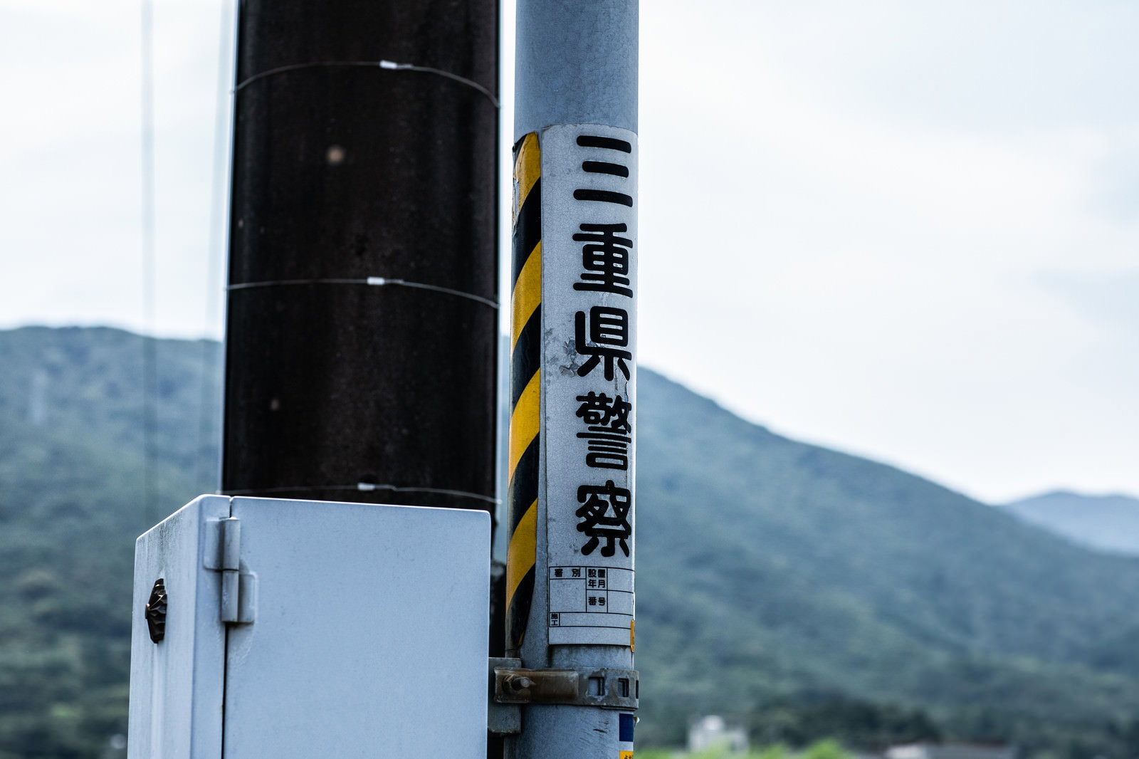 電柱に設置された青と白の三重県警察の看板