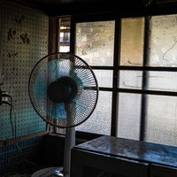 昭和レトロな古い家屋に置かれた青い扇風機の写真