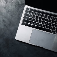 光を帯びるノートパソコンのキーボードと作業環境の写真