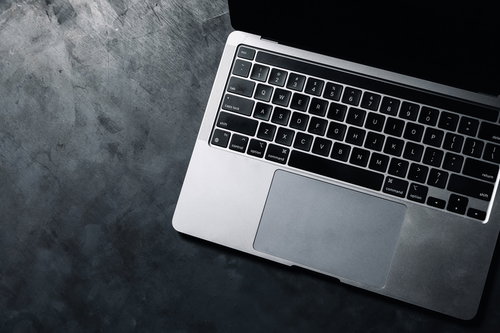 光を帯びるノートパソコンのキーボードと作業環境