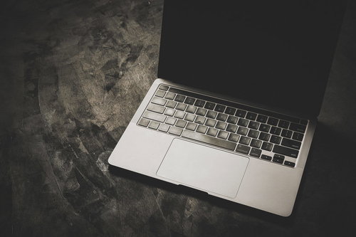 暗い床に置かれた光に照らされるノートPC