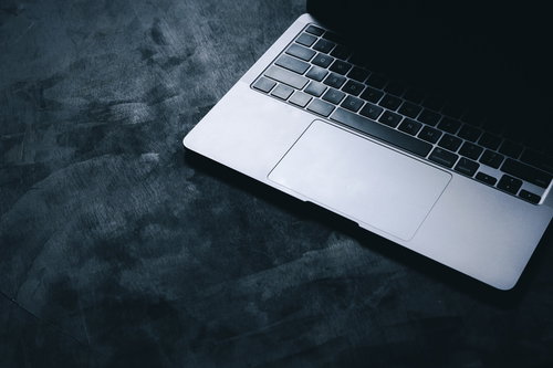 グレーの天板に置かれたノートパソコンを照らす光
