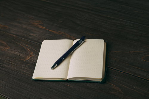 白紙の手帳に置いたボールペン、ドット罫ノートのデスク