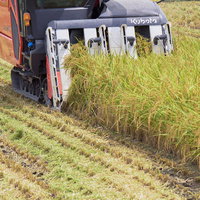 クボタのコンバインで稲を刈る収穫の時期の農作業風景の写真