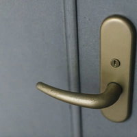 使い込まれたゴールドカラーのドアノブと楕円形プレートの写真