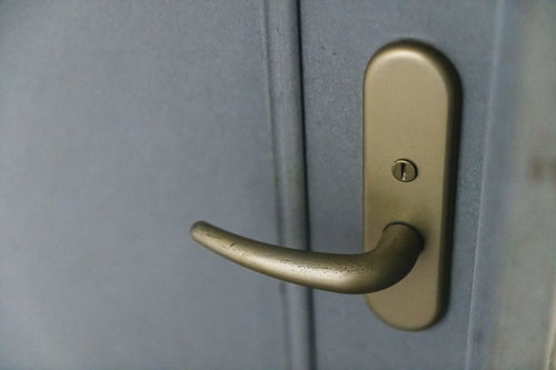 使い込まれたゴールドカラーのドアノブと楕円形プレート