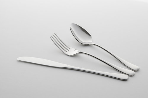 白い背景に並べた銀のナイフ・フォーク・スプーン