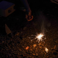 暗闇で火花が散る手持ち花火の光景、夏夜の思い出の写真