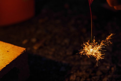 夜間に燃える線香花火のパチパチと散る火花
