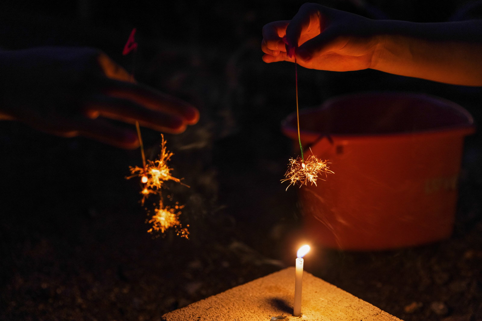 Night scene with the glow of sparklers and candles in the darkness
