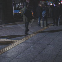 夜間の駅前通りで帰り道を歩く人たちの群衆の写真