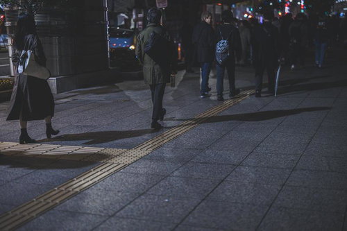 夜間の駅前通りで帰り道を歩く人たちの群衆