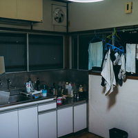 部屋干しが残るワンルームアパートのキッチン一室の写真