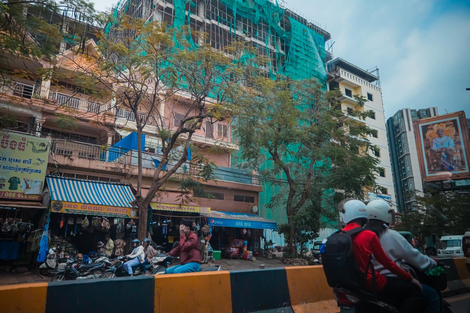 カンボジアの街並みに建つ建設中のマンションと商店街の風景