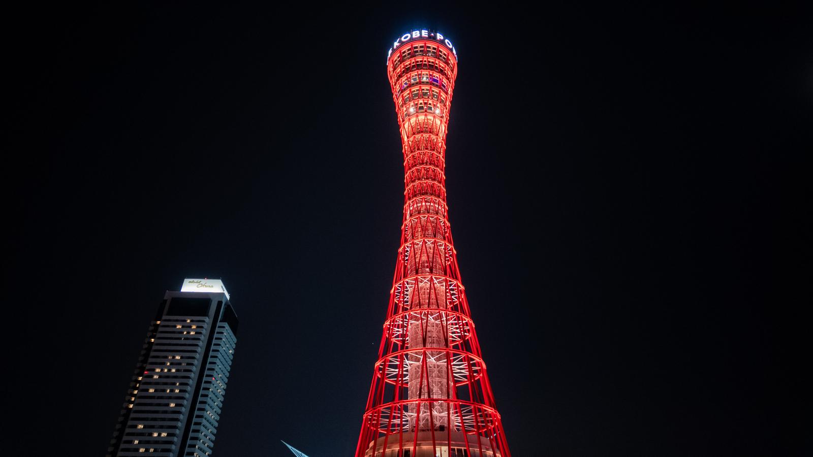 赤くライトアップされた神戸ポートタワーが夜空に聳える