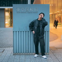 東京国税局の前で頭を抱えて悩む男性ビジネスマンの写真