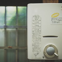 昭和レトロな台所に設置されたガス給湯器、壁付け式の古い住宅設備の写真