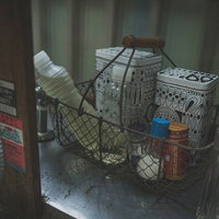 昭和レトロな台所の棚に並ぶ調味料の瓶と容器の写真