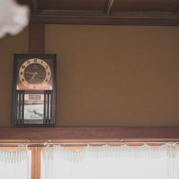 古民家の和室に掛けられた丸い掛時計の風情ある空間の写真