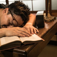 古民家の書斎で本を読みながら寝落ちする男性の写真